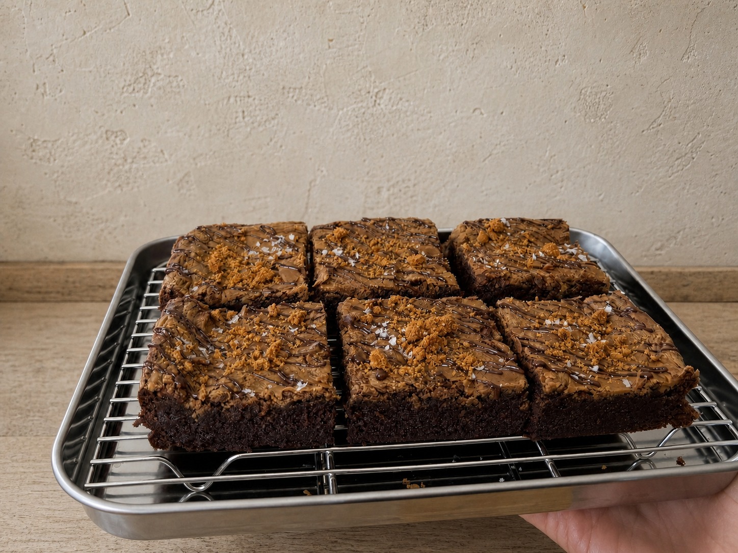 Six Miso Biscoff brownies arranged on a stainless-steel tray