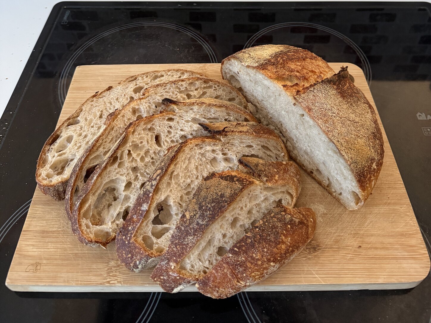 Sliced sourdough loaf showing its open crumb on a wooden board